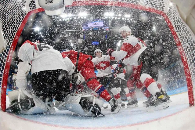 Switzerland's goaltender Leonardo Genoni (L) and his teammate Mirco Muller (R) defend the goal during the men's preliminary round group B match of the Beijing 2022 Winter Olympic Games ice hockey competition between Czech Republic and Switzerland, at the National Indoor Stadium in Beijing on February 11, 2022. (Photo by Harry How/Pool via AFP Photo)