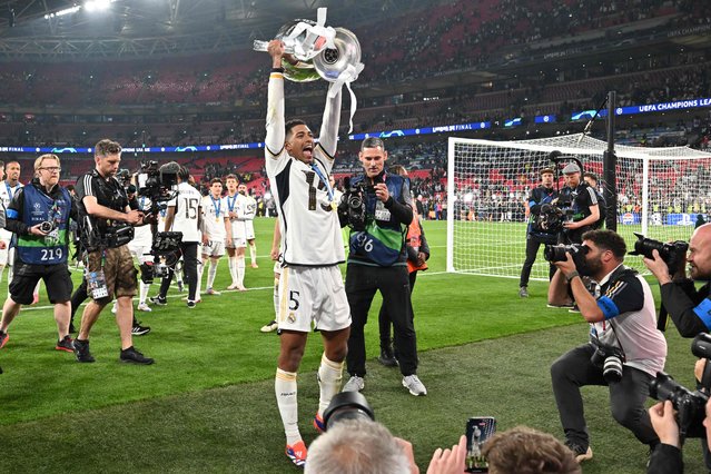 Real Madrid's English midfielder #5 Jude Bellingham holds the trophy as he celebrates the victory at the end of the UEFA Champions League final football match between Borussia Dortmund and Real Madrid, at Wembley stadium, in London, on June 1, 2024. (Photo by Glyn Kirk/AFP Photo)