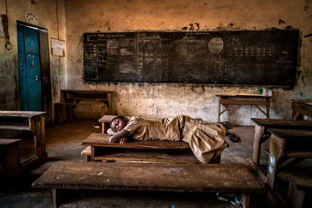 Sweet Dreams by Aragon Renuncio, Burkina Faso. A girl sleeps on a desk inside her schoolroom. Extreme rains have tripled in the Sahel in the last 35 years because of global warming. Climate change has caused 70 episodes of torrential rains in the last decade although the region also suffers severe droughts. (Photo by Aragon Renuncio/CIWEM Environmental Photographer of the Year 2019)