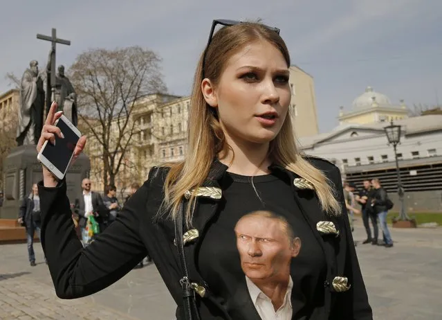 Pro-Kremlin political activist Maria Katasonova, wearing a T-shirt with a portrait of president Vladimir Putin, arrives to meet with opposition activist Maria Baronova before an unsanctioned protest in downtown Moscow, Russia, Saturday, April 29, 2017. Several hundred demonstrators are gathered in central Moscow, trying to move to the nearby presidential administration building to present letters calling on Vladimir Putin not to run for a fourth term in office in 2018. (Photo by Alexander Zemlianichenko/AP Photo)