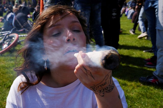 A person smokes marijuana as marijuana enthusiasts mark the informal annual cannabis holiday, 4/20 (four-twenty), corresponding to the numerical figure widely recognized within the cannabis subculture as a symbol for all things related to marijuana, in Hyde Park in London, Britain on April 20, 2023. (Photo by Maja Smiejkowska/Reuters)