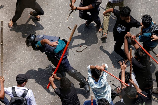 A police officer is beaten by mob during a clash between anti-quota supporters, police and Awami League supporters at the Rampura area in Dhaka, Bangladesh on July 18, 2024. (Photo by Mohammad Ponir Hossain/Reuters)