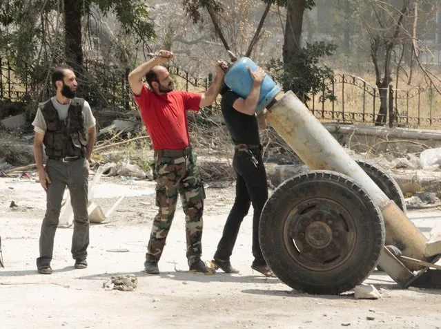 “Free Syrian Army” fighters prepare an improvised explosive to fire towards forces loyal to Syria's President Bashar al-Assad, in Aghyour area in the city of Aleppo May 22, 2014. (Photo by Abdalrhman Ismail/Reuters)