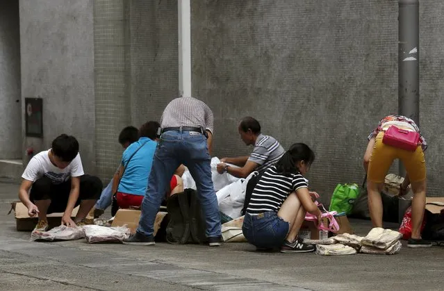 People unpack frozen beef ribs from the U.S. on a back street at an industrial area in Hong Kong, before being hand carried and smuggled across the border into mainland China, July 13, 2015. As China's appetite for meat continues to grow, a crackdown is under way on illegal smuggling from Vietnam and Hong Kong. (Photo by Bobby Yip/Reuters)