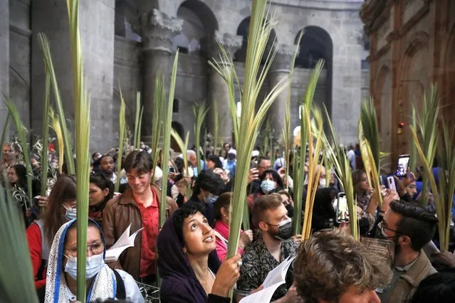 Faithful carry palm branches during the Palm Sunday procession in the Old city of Jerusalem, 10 April 2022. Palm Sunday for Roman Catholic devotees symbolically marks the biblical account of the entry of Jesus Christ into Jerusalem, signaling the start of the Holy Week. (Photo by Abir Sultan/EPA/EFE)