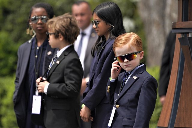 A child dressed to look like a Secret Service agent stands on the South Lawn of the White House as President Joe Biden welcomes children to the White House for “Take Your Child to Work Day”, Thursday, April 27, 2023, in Washington. (Photo by Evan Vucci/AP Photo)