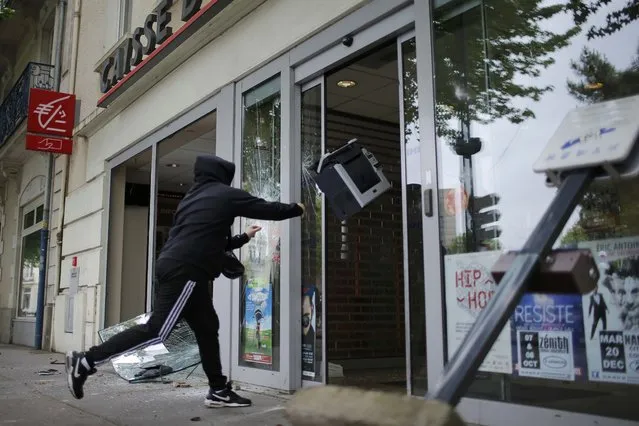  A youth throws a printer into a bank during a demonstration to protest the government's proposed labour law reforms in Nantes, France, May 26, 2016. (Photo by Stephane Mahe/Reuters)