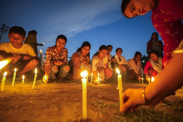 Women light candles as they stage a silent protest against the rape and killing of a trainee doctor at a government hospital last week, in Guwahati, India, Friday, August 16, 2024. (Photo by Anupam Nath/AP Photo)