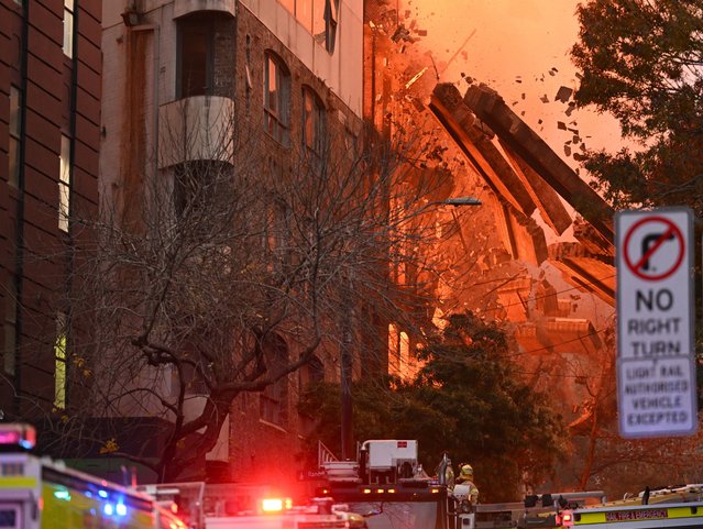 A wall collapses during a building fire in the Central Business District of Sydney, Australia, 25 May 2023. Fire and Rescue New South Wales said more than 100 firefighters were deployed to the area to battle the fire that erupted in the seven-storey building. (Photo by Dean Lewins/EPA)