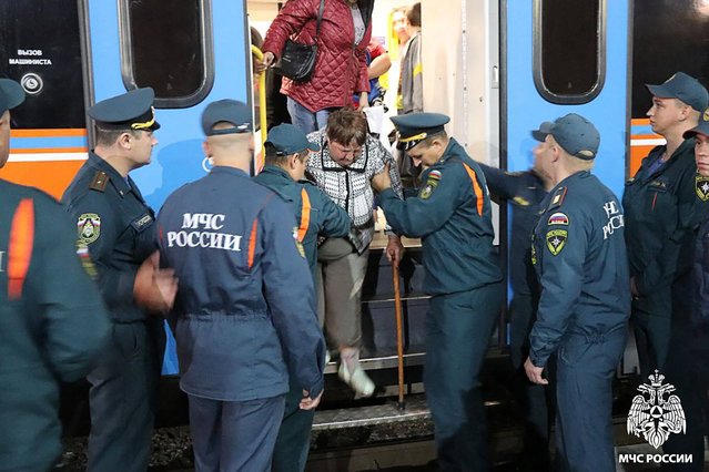 This handout photograph released by the Russian Emergency Situations Ministry press service shows the Ministry's personnel assisting people who have been evacuated from the border settlements of the Kursk region, as they arrive at a railway station in Oryol on August 9, 2024. Russia's army said it was still fighting a Ukrainian incursion into its western Kursk border region, four days after Kyiv's forces stormed across the border in a surprise attack. (Photo by Russian Emergency Situations Ministry/AFP Photo)