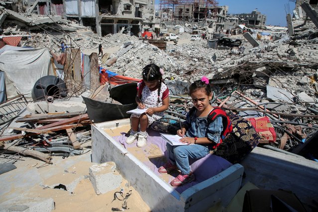 Palestinian students sit on the rubble after attending a class in a tent set up on the ruins of the house of teacher Israa Abu Mustafa, as war disrupts a new school year, amid the Israel-Hamas conflict, in Khan Younis, in the southern Gaza Strip, on September 4, 2024. (Photo by Hatem Khaled/Reuters)