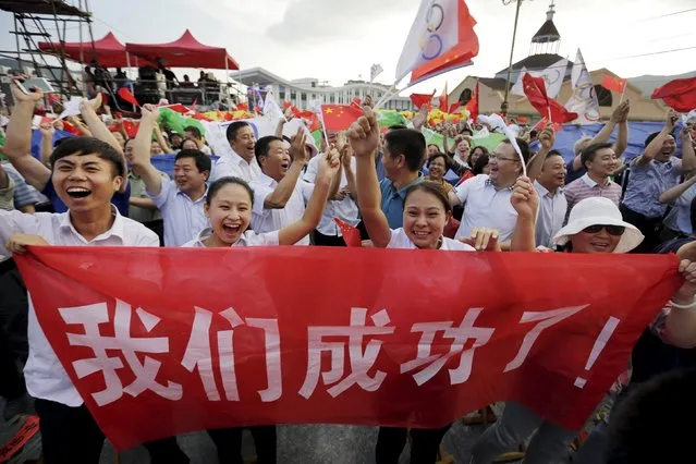 Local residents celebrate with a banner “We succeeded!” after Beijing was chosen to host the 2022 Winter Olympics at a square in Chongli county of Zhangjiakou, jointly bidding to host the 2022 Winter Olympic Games with capital Beijing, July 31, 2015. Beijing was chosen by the International Olympic Committee (IOC) to host the 2022 Winter Olympics on Friday, becoming the first city to be awarded both summer and winter Games. (Photo by Jason Lee/Reuters)