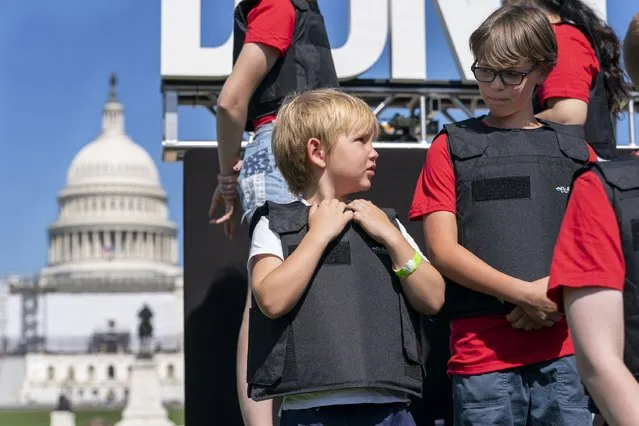 Wearing body armor, Jacob Kelly, 6, talks with Cal Neaville, 11, right, during a gun safety reform rally, Monday, June 6, 2022, outside the U.S. Capitol in Washington. (Photo by Jacquelyn Martin/AP Photo)