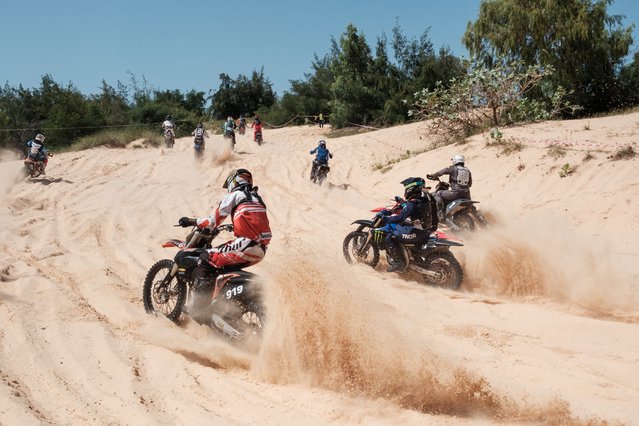 Riders race up a sand dune during the Senegal Motocross Championship in Dakar on October 13, 2024. The Senegal Motocross championships where held on a course in the Dunes near the famous Lac Rose near the country's capital Dakar, where riders coming from Ivory Coast, Burkina Faso and Morocco as well as locals competed for the national prize in various categories. (Photo by Guy Peterson/AFP Photo)