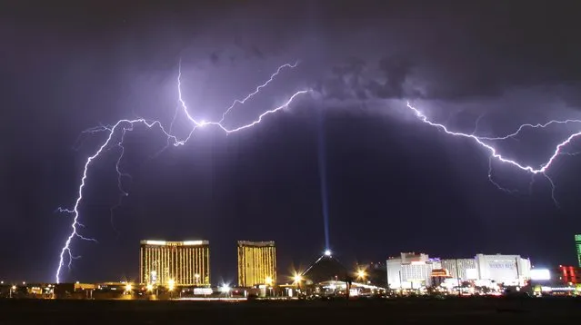 A monsoon lightning storm strikes over the Mandalay Bay Resorts and Casino and Luxor hotels in Las Vegas, Nevada late July 7, 2014. Monsoon storms are forecast for the the rest of the week in the Nevada and Arizona states. The Luxor Sky Beam can be seen shining into the sky from the top of the hotel's pyramid structure. (Photo by Gene Blevins/Reuters)