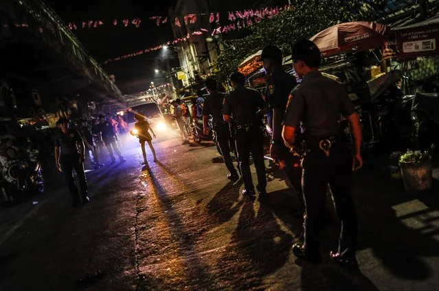 Police patrol a shanty community at night during curfew, June 8, 2016, in Manila, Philippines. (Photo by Dondi Tawatao/Getty Images)