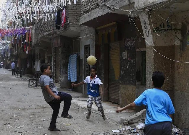 Egyptian boys play soccer in an alleyway at the Boulaq El Dakrour district of Giza, near Cairo, Egypt, Sunday, July 5, 2015. (AP Photo/Hassan Ammar)