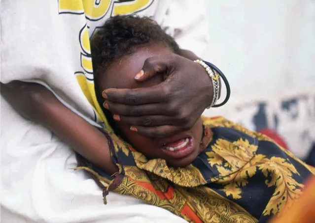 Hudan Mohammed Ali, 6, screams in pain while undergoing circumcision in Hargeisa, Somalia, June 17, 1996. Her sister Farhyia Mohammed Ali, 18, holds her so she cannot move. (Photo by Jean-Marc Bouju/AP Photo)