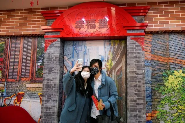 Wang, 32, and his wife Shi, 30, pose for a selfie as Wang holds their marriage certificates at a marriage registry office on Valentine's Day in Shanghai, China, as the country is hit by an outbreak of the novel coronavirus, February 14, 2020. (Photo by Aly Song/Reuters)