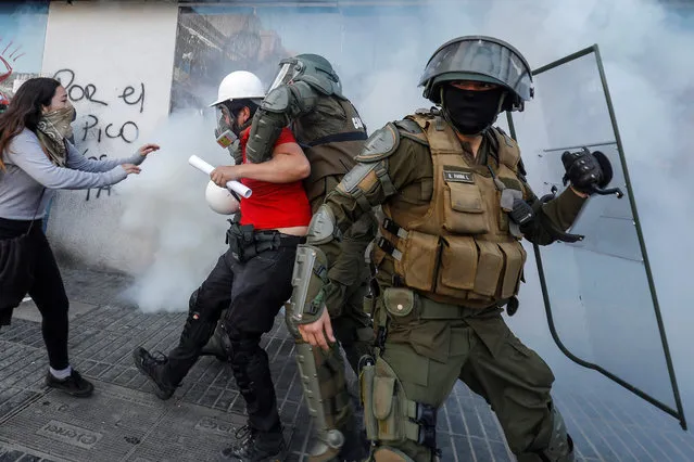 Policemen arrest a demonstrator during protests against the Vina del Mar Music Festival, in vina del Mar, Chile, 24 February 2020. According to media reports, more authorities have been deployed in an attempt to maintain order in the coastal city. (Photo by Leandro Torchio/EPA/EFE)