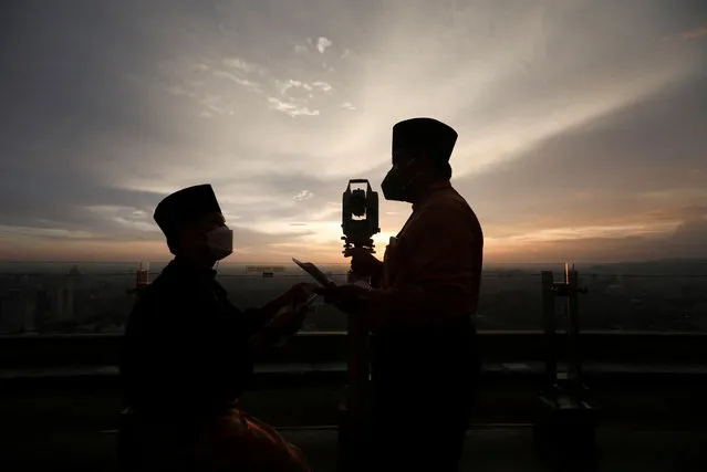 Silhouettes of Malaysia's Islamic Authority's officers and a theodolite which they use to perform “rukyah”, the sighting of the new moon which signals the start of the holy month of Ramadan, are seen in Kuala Lumpur, Malaysia, April 1, 2022. (Photo by Hasnoor Hussain/Reuters)