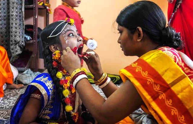 A Hindu woman dresses up a child as Hindu deity Radha before a procession to mark  Janmashtami in Srinagar, Indian controlled Kashmir, Thursday, September 7, 2023. Janmashtami, marks the birthday of Hindu god Krishna. (Photo by Mukhtar Khan/AP Photo)