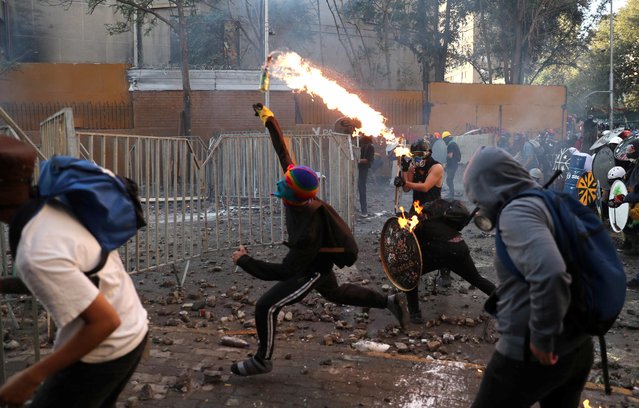 A demonstrator throws a Molotov cocktail during a protest against Chile's government in Santiago, Chile on March 6, 2020. (Photo by Ivan Alvarado/Reuters)