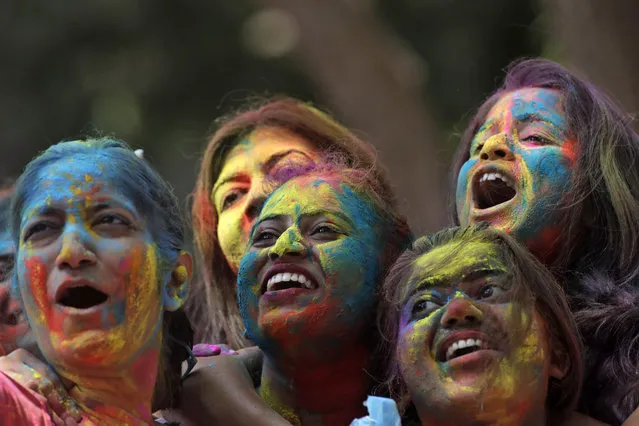 Women with their faces smeared with colored powder cheer during celebrations marking the Holi festival in Mumbai, India, Tuesday, March 10, 2020 (Photo by Rajanish Kakade/AP Photo)
