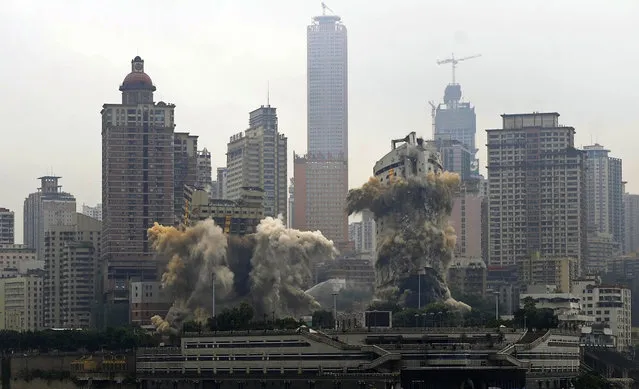 A view shows the Three Gorges Hotel (L) and the passenger terminal of Chongqing Port (R) collapsing after demolition by explosives in Chongqing, southwest China, August 30, 2012. (Photo by Reuters/China Daily)