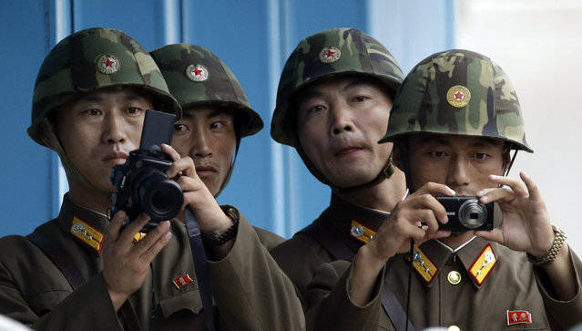 In this July 27, 2013, file photo, North Korean soldiers watch the south side with cameras as Gen. James D. Thurman, the commander of United Nations Command, South Korea-U.S. Combined Forces Command, and U.S. Forces Korea, and Korean War veterans and officials visit after attending a ceremony marking the 60th anniversary of the Korean War Armistice Agreement at the truce villages of Panmunjom in Paju, South Korea. Straddling the world's most heavily fortified border, the Korean truce village of Panmunjom is a potentially dangerous flashpoint where North Korean soldiers hacked to death two American soldiers at the height of the Cold War. (Photo by Lee Jin-man/AP Photo)