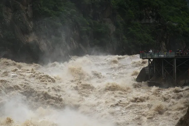 People watch the flooded Jinsha River at a sightseeing platform of Tiger Leaping Gorge, in Diqing, Yunnan Province, China, July 15, 2016. (Photo by Reuters/Stringer)