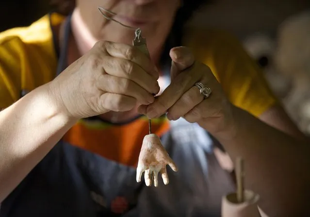 Gail Grainger, a 14-year veteran doll restorer, is pictured as she adds fingers to a damaged dolls hand in her workshop at Sydney's Doll Hospital, May 20, 2014. (Photo by Jason Reed/Reuters)