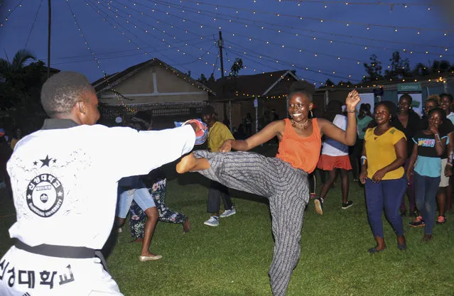 In this photo taken Saturday, March 7, 2020, a Ugandan woman tries out self-defense during the Mara Mara peace festival in Kampala, Uganda. The festival drew inspiration from the African Union's declaration of 2020 as the year for “silencing the guns” on a continent that has long faced violence ranging from civil war to ethnic rivalries and rebel insurgencies. (Photo by Ronald Kabuubi/AP Photo)