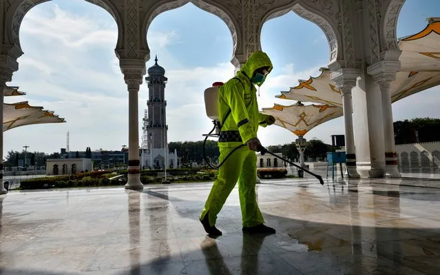 An Indonesian police officer sprays disinfectant in the Baiturrahman grand mosque, amid concerns of the COVID-19 coronavirus, in Banda Aceh on March 20, 2020. (Photo by Chaideer Mahyuddin/AFP Photo)