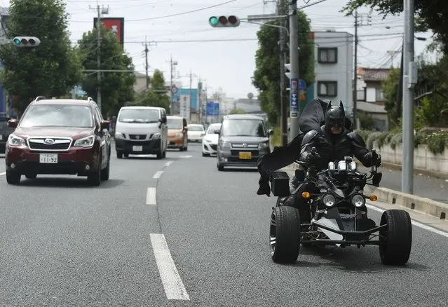 A 41-year-old man going by the name of Chibatman rides his “Chibatpod” on the road in Chiba, east of Tokyo, August 31, 2014. The man, who dresses up as the comic book superhero Batman, came up with his moniker after adding a prefix of the first three letters of the city name, of which he roams on his three-wheeled motorcycle. (Photo by Yuya Shino/Reuters)