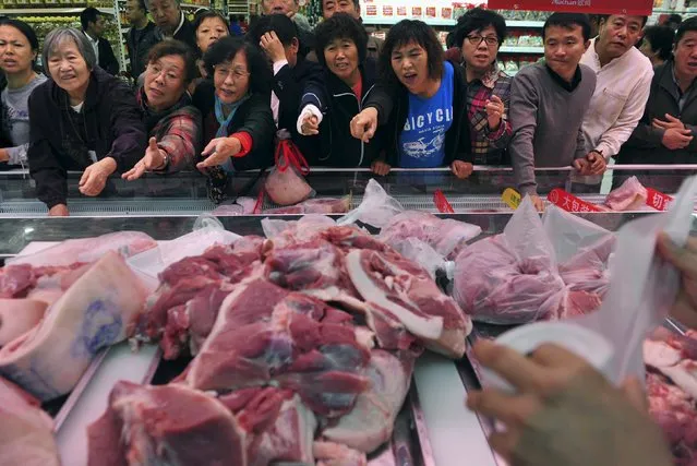 Customers point to chopped pork for sale during a promotional event at a supermarket in Shenyang, Liaoning province, in this November 9, 2012 file photo. (Photo by Reuters/Stringer)