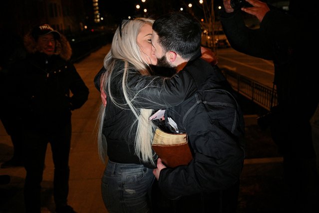 Edward “Jake” Lang, one of the defendants who was released after being pardoned, holds a Bible while kissing his girlfriend, Rachel Myers, outside of the DC Central Detention Facility, on January 21, 2025. (Photo by Jon Cherry/Reuters)