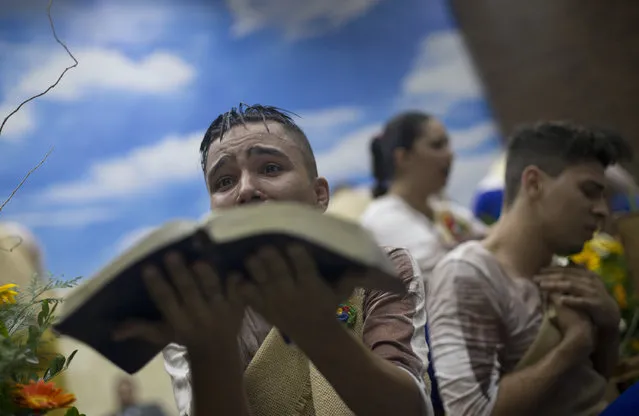 A young devotee performs while holding a Bible during a service at the Contemporary Christian Church in Rio de Janeiro, Brazil, Monday, September 7, 2015. At the Contemporary Christian Church, which on Monday celebrated its ninth anniversary and the opening of its ninth branch with a raucous, theatrical service, homosexuality is celebrated rather than stigmatized. (Photo by Silvia Izquierdo/AP Photo)