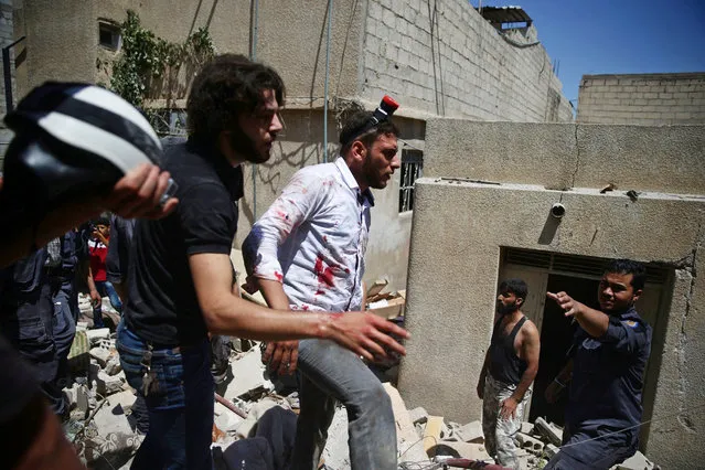 A civil defence member with blood stains on his shirt walks over rubble at a site hit by airstrikes in the rebel-held Douma neighbourhood of Damascus, Syria July 27, 2016. (Photo by Bassam Khabieh/Reuters)