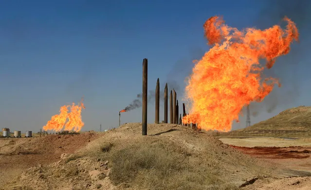 Flames emerge from flare stacks at the oil fields in Kirkuk, Iraq on October 18, 2017. (Photo by Alaa Al-Marjani/Reuters)