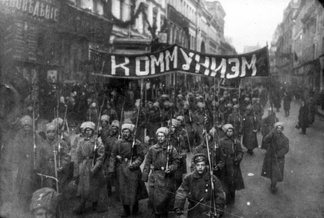 In this photo taken in October 1917, provided by Russian State Documentary Film and Photo Archive, Russian State Documentary Film and Photo Archive, armed soldiers carry a banner reading 'Communism' march alone Nikolskaya street towards to the Kremlin Wall in Moscow, Russia. The 1917 Bolshevik Revolution was long before the digital revolution allowed anyone to instantly document events. But the clumsy cameras of the time still caught some images that capture the period's drama. (Photo by Russian State Documentary Film and Photo Archive via AP Photo)