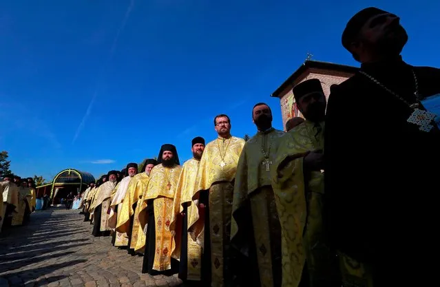 Romanian Orthodox priests attends a short open-air mass while accompanying the relics of Saint Dimitrie Basarabov, the patron saint of Romania's capital, durnig a procession in front of Patriarchal Cathedral in Bucharest, Romania, 24 October 2022. Romanians will celebrate Saint Dimitrie Basarabov on 27 October 2022. Thousands of pilgrims from all over the country are expected in Bucharest to worship the relics of the patron Saint of Bucharest the next few days. (Photo by Robert Ghement/EPA/EFE/Rex Features/Shutterstock)