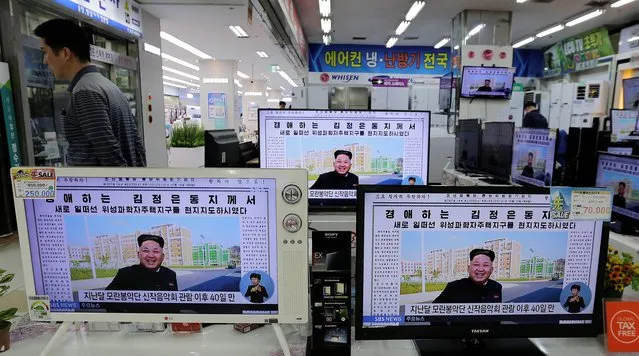 A man walks past TV monitors displaying a news program at an electronic shop in Seoul, South Korea, Tuesday, October 14, 2014, showing a North Korean newspaper with a photo of North Korean leader Kim Jong Un smiling, reportedly during his first public appearance in five weeks in Pyongyang, North Korea. (Photo by Ahn Young-joon/AP Photo)