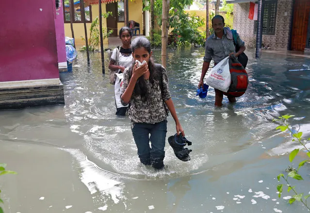 Residents carry their belongings as they evacuate their house after flooding caused by Cyclone Ockhi in the coastal village of Chellanam in the southern state of Kerala, India, December 2, 2017. (Photo by Sivaram V/Reuters)