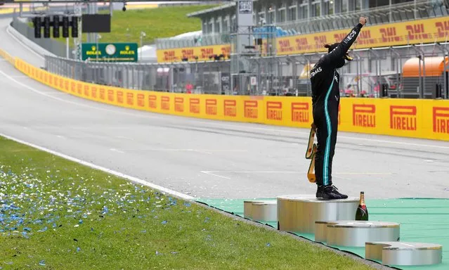 Mercedes' British driver Lewis Hamilton raises a fist on the podium after the Formula One Styrian Grand Prix race on July 12, 2020 in Spielberg, Austria. (Photo by Leonhard Foeger/Reuters/Pool)