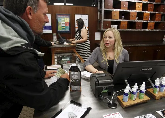 Jackie Perte helps a customer at Shango Cannabis shop on first day of legal recreational marijuana sales beginning at midnight in Portland, Oregon October 1, 2015. (Photo by Steve Dipaola/Reuters)