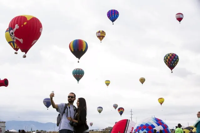 A couple poses for a selfie as hundreds of hot air balloons take off from a field during the 2015 Albuquerque International Balloon Fiesta in Albuquerque, New Mexico, October 4, 2015. (Photo by Lucas Jackson/Reuters)