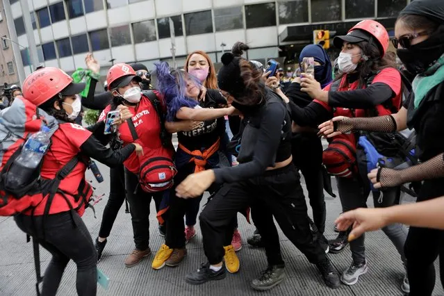Members of NGO Independent Space Marabunta (Espacio Libre Independiente Marabunta) try to stop a fight among protesters during a march demanding justice for the victims of gender violence and femicides in Mexico City, Mexico on August 16, 2020. (Photo by Raquel Cunha/Reuters)