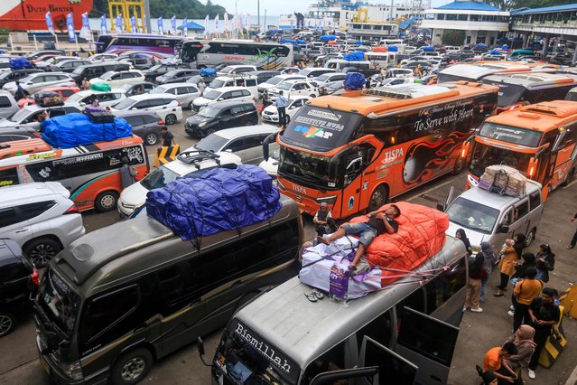 A man falls asleep on top of a vehicle as prospective homecoming travellers crowd Merak Port in Cilegon on March 28, 2025, to celebrate Eid al-Fitr to mark the end of Ramadan. (Photo by Dziki Oktomauliyadi/AFP Photo)