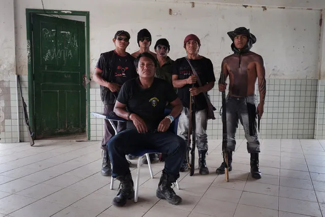 Olimpio Iwyramu Guajajara, seated, coordinates the Guardians of the Forest, stationed in a school in Araribóia Indigenous Reserve, Maranhão, Brazil on August 7, 2015. Loggers have been stealing hardwood trees from indigenous lands in Brazil. The Guardians of the Forest are an armed militia formed by the Guajajara tribe to protect their reserve. (Photo by Bonnie Jo Mount/The Washington Post)